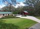 Sprawling property showcasing a red barn, fountain, mature trees, and detached garage at 13607 Mcintosh Rd, Thonotosassa, FL 33592