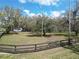 Lush green yard, adorned with mature trees and a charming wooden fence at 13607 Mcintosh Rd, Thonotosassa, FL 33592