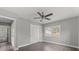 Gray bedroom features wood-look floors, fresh paint, closet, and adjacent bathroom at 1515 W Lambright St, Tampa, FL 33604