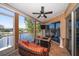 Cozy screened balcony offering lake view with comfortable seating and a ceiling fan at 18 Crescent S Pl, St Petersburg, FL 33711