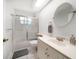 Bright bathroom features a tub, shower, and modern sink vanity with a round mirror at 18 Crescent S Pl, St Petersburg, FL 33711