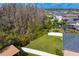 Aerial view of a backyard featuring a lush lawn, mature trees, and a white privacy fence at 19476 Paddock View Dr, Tampa, FL 33647