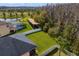 Aerial view showcasing the backyard, featuring lush greenery, a sports court, and a privacy fence at 19476 Paddock View Dr, Tampa, FL 33647