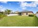 Expansive backyard featuring lush green grass, a screened-in patio, and a white vinyl fence for privacy at 19476 Paddock View Dr, Tampa, FL 33647