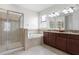 Bathroom with a glass-enclosed shower, soaking tub, granite counters, and dual sinks at 19476 Paddock View Dr, Tampa, FL 33647