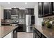 A bright kitchen showcasing stainless steel appliances, dark cabinets, and stone countertops at 19476 Paddock View Dr, Tampa, FL 33647