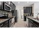 A kitchen showcasing stainless steel appliances, dark cabinets, stone countertops, and ceramic tile flooring at 19476 Paddock View Dr, Tampa, FL 33647