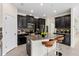A modern kitchen featuring dark cabinets, stainless steel appliances, and a granite countertop island with barstool seating at 19476 Paddock View Dr, Tampa, FL 33647
