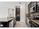 A partial kitchen view, featuring stainless steel appliances, dark cabinets, and stone countertops at 19476 Paddock View Dr, Tampa, FL 33647