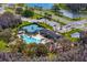Scenic aerial view of community amenities: sparkling pool, clubhouse, and tennis courts at 19476 Paddock View Dr, Tampa, FL 33647