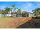Expansive backyard with a screened-in pool, palm trees, and ample space for outdoor activities at 22516 Magnolia Trace Blvd, Lutz, FL 33549