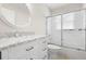 Bathroom features a vanity with granite countertop, round mirror, and shower over tub at 22516 Magnolia Trace Blvd, Lutz, FL 33549