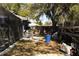 View of the backyard showing the side of the screened in pool, mature trees and an exterior fence at 2332 Seward Dr, Sarasota, FL 34234
