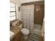 Bathroom with a beach themed shower curtain, tiled walls, and storage for an organized space at 2332 Seward Dr, Sarasota, FL 34234