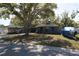 Charming single-story home with a well-maintained lawn and mature shade tree on a sunny day at 2332 Seward Dr, Sarasota, FL 34234