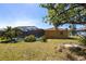 View of the spacious backyard, including the screened-in pool area with mature landscaping at 2466 Lake View Blvd, Port Charlotte, FL 33948