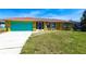 Charming single-story home featuring a vibrant blue garage door and a well-maintained front yard at 2466 Lake View Blvd, Port Charlotte, FL 33948