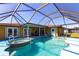 This screened-in pool area features a hot tub and easy access to the home's interior at 2466 Lake View Blvd, Port Charlotte, FL 33948