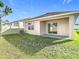 View of the backyard featuring the home's patio and sliding glass door and a well-maintained lawn at 2871 Common Fig Run, Wesley Chapel, FL 33543