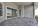 Covered back patio featuring neutral color scheme and tiled flooring; sliding glass doors to indoor living at 33759 Ocean Spray Ln, Wesley Chapel, FL 33543