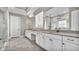 Elegant bathroom featuring dual vanities, marble floors, quartz countertops and a frameless glass shower at 33759 Ocean Spray Ln, Wesley Chapel, FL 33543