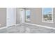 Bright bedroom showcasing marble tile flooring, two windows, and neutral paint, with a closet door at 33759 Ocean Spray Ln, Wesley Chapel, FL 33543