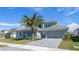 Modern home with two-car garage, well-manicured lawn, and professional landscaping at 33759 Ocean Spray Ln, Wesley Chapel, FL 33543