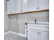 Bright laundry room with white cabinetry, modern sink and faucet, and ample storage for household needs at 33759 Ocean Spray Ln, Wesley Chapel, FL 33543