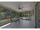 Inviting screened-in porch with tiled flooring, a ceiling fan, outdoor seating, and views of the lush backyard at 3456 Roslyn Rd, Venice, FL 34293