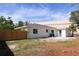 This backyard features a newly painted white house, a wooden fence, and a concrete patio for outdoor entertaining at 4019 W Lemon St, Tampa, FL 33609