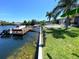 Waterfront backyard featuring a private dock, patio with lounge chairs, and lush landscaping at 4108 Daisy Dr, Hernando Beach, FL 34607