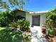Charming home featuring a welcoming front entry with lush landscaping and a well-manicured lawn at 4108 Daisy Dr, Hernando Beach, FL 34607