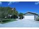 Charming single-story home featuring an attached garage, a well-manicured lawn, and an American flag at 4108 Daisy Dr, Hernando Beach, FL 34607