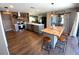 Open kitchen features wood floors, center island with seating, brick accent wall, and stainless steel appliances at 4108 Daisy Dr, Hernando Beach, FL 34607