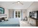 Bright main bedroom with a ceiling fan, tile flooring, and a scenic view of the backyard at 5211 Gato Del Sol Cir, Wesley Chapel, FL 33544