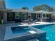 Backyard with a pool, spa, and outdoor seating area featuring stylish blue cushioned chairs at 524 Park S St, St Petersburg, FL 33707