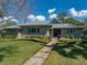 Charming stone home featuring manicured landscaping and a walkway leading to a stylish double-door entrance at 524 Park S St, St Petersburg, FL 33707