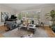 Spacious living room featuring a grand piano, large windows with shutters, and comfortable seating arrangements at 524 Park S St, St Petersburg, FL 33707