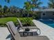 Relaxing lounge chairs by the pool with lush landscaping and a view of the backyard at 524 Park S St, St Petersburg, FL 33707