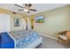Bright bedroom featuring a ceiling fan, tile floors, and a wall-mounted TV, plus a pineapple painting and comfortable furniture at 6181 Bahia Del Mar Blvd # 112, St Petersburg, FL 33715