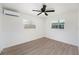 Bright bedroom with two windows, vinyl plank flooring, and a modern ceiling fan at 679 71St N Ave, St Petersburg, FL 33702