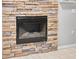 Modern fireplace with a stone surround and a sleek black firebox at 6841 Collingswood Ct, New Port Richey, FL 34655