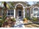 Inviting front entrance with arched entryway, white columns, and lush landscaping at 6841 Collingswood Ct, New Port Richey, FL 34655