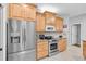 Well-equipped kitchen with stainless steel appliances and light wood cabinetry at 6841 Collingswood Ct, New Port Richey, FL 34655