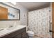 Cozy bathroom featuring a gray vanity and a shower with a charming floral curtain at 6905 El Camino Paloma St, Port Richey, FL 34668