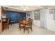 Cozy dining room with hardwood table, blue accent wall, and a window offering natural light at 6905 El Camino Paloma St, Port Richey, FL 34668