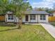 Charming home featuring a well-manicured lawn, fresh landscaping, and a welcoming front entrance at 7013 24Th S Ave, Tampa, FL 33619