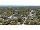 Expansive aerial view of a suburban neighborhood featuring tree-lined streets and homes with swimming pools, with a city skyline at 8006 N Ola Ave, Tampa, FL 33604