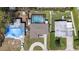 Aerial view of a home featuring a screened pool, spacious yard, and driveway at 8006 N Ola Ave, Tampa, FL 33604