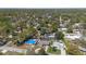 Aerial view of homes in a lush neighborhood. One home features a screened pool at 8006 N Ola Ave, Tampa, FL 33604